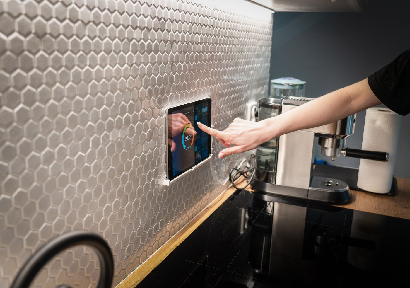 Pessoa a controlar a casa inteligente num painel tátil de parede