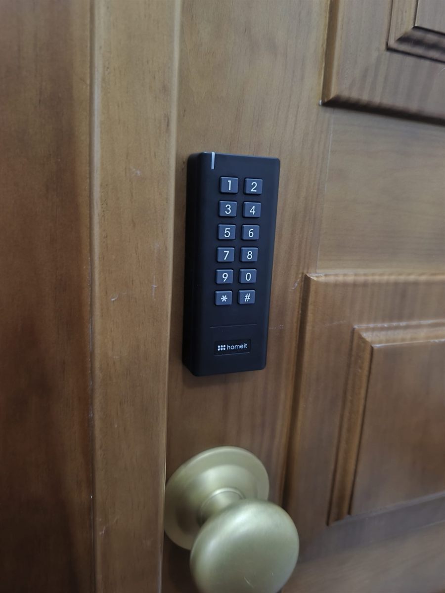 Teclado de acesso homeit instalado numa porta de madeira de apartamento